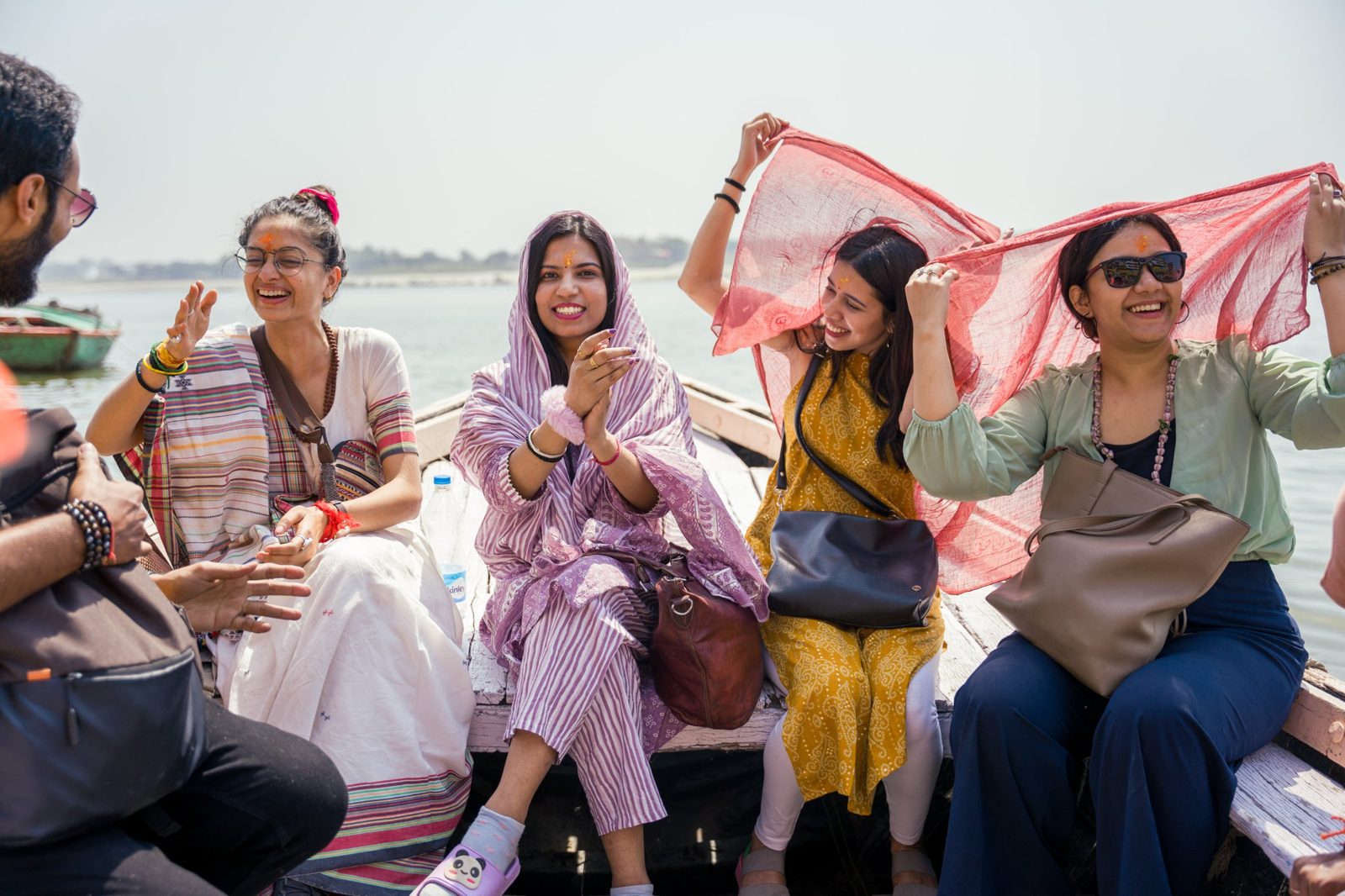 Seekers laughing together on a boat on the Ganga
