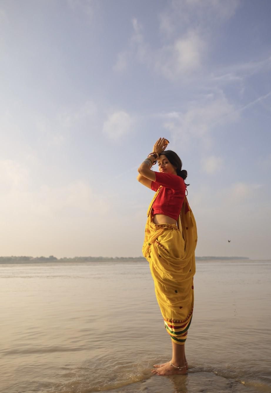 Kamya offering Sūrya arghya in the Ganga at sunrise